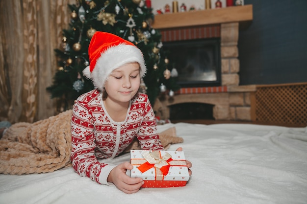 Menina com um presente na árvore de Natal
