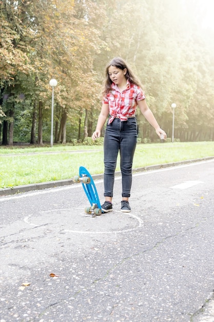 Menina com um skate caminhando no parque