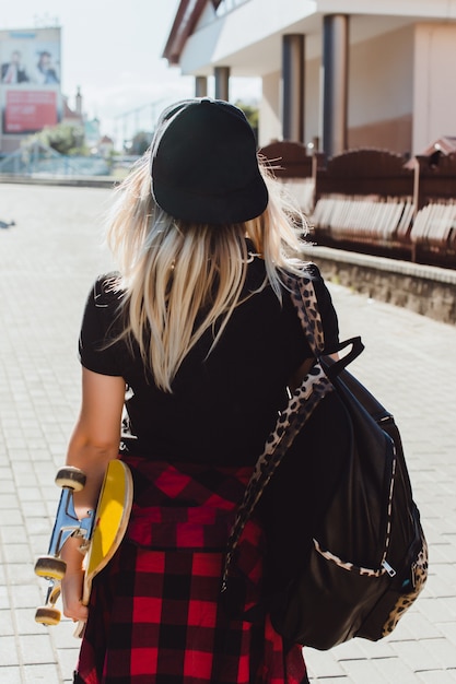 Foto menina com um skate em uma mão