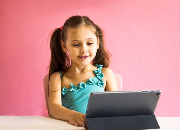 Menina com um tablet na mesa