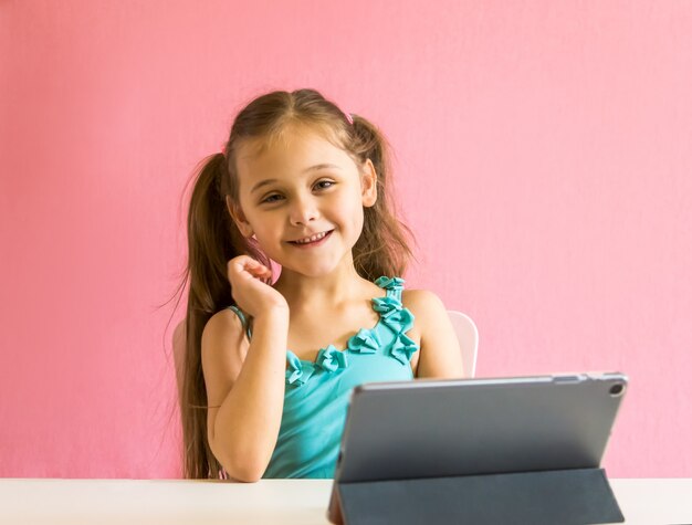 Menina com um tablet na mesa