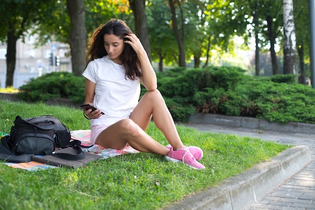 Menina com um telefone na mão. Tecnologia, comunicação.