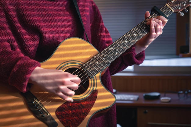 Menina com um violão sob o sol através das cortinas