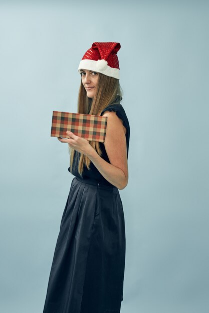 Menina com uma caixa de presente nas mãos e um chapéu de Papai Noel