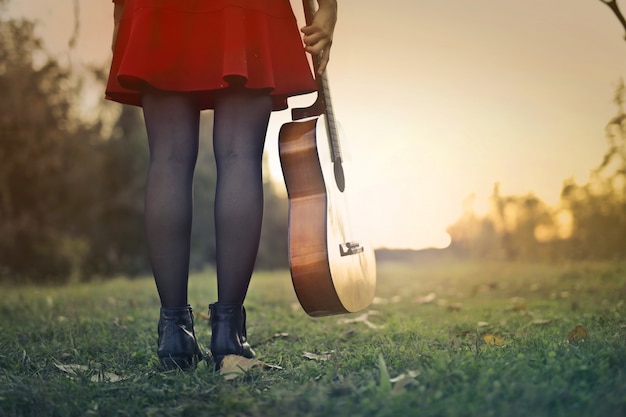 Menina com uma guitarra por do sol