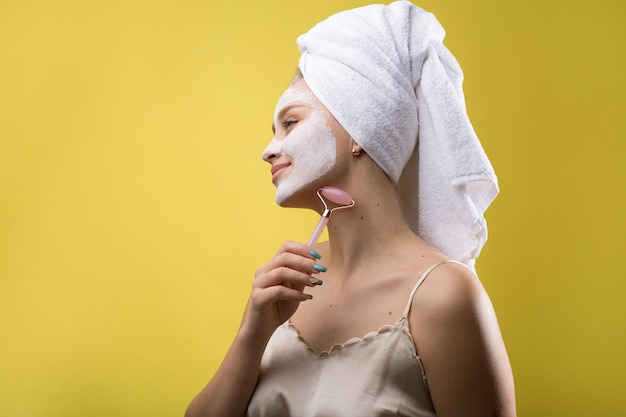 Menina com uma máscara cosmética no rosto em uma toalha branca.