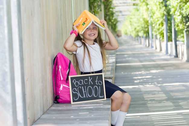 Foto menina com uma mochila no parque. primeiro dia de aula