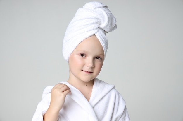Menina com uma túnica branca e uma toalha na cabeça
