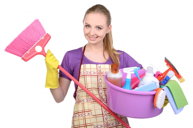 Menina com uma vassoura e aparelhos para limpeza do quarto.