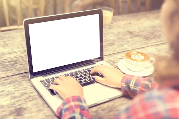 Menina com uma xícara de café e um laptop em branco simulado