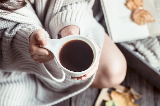 Menina com uma xícara de café nas mãos