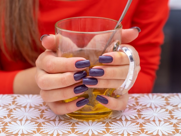 Menina com uma xícara de chá. Menina com unhas lindas segurando uma xícara de chá