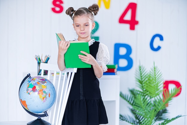 Menina com uniforme escolar segurando um livro