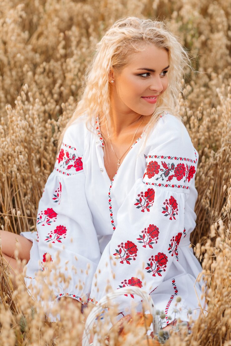Foto menina com vestido bordado branco sentada no campo