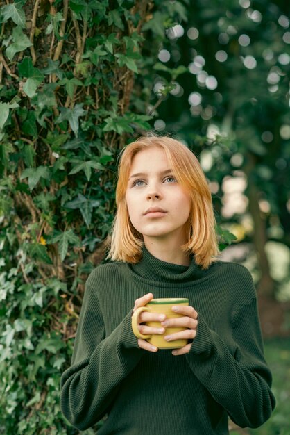 Menina com xícara de chá de ervas na primavera