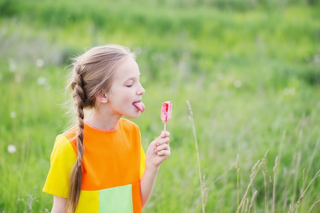 Menina come sorvete no verão