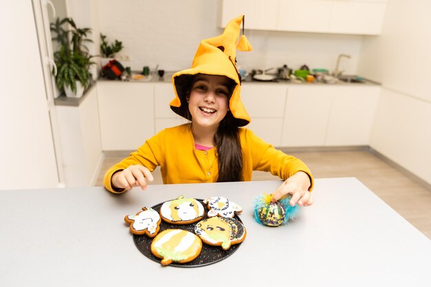 Menina comendo biscoitos em uma festa de halloween.