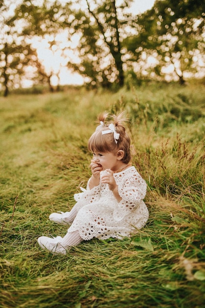 Menina comendo croissant na floresta