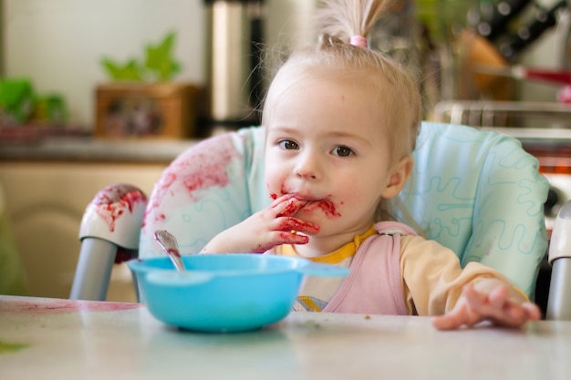 Foto menina comendo na cozinha