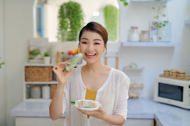 Menina comendo rolinhos primavera frescos com camarões