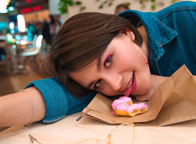 Menina comendo rosquinha no shopping, língua, rosquinha, quadríceps