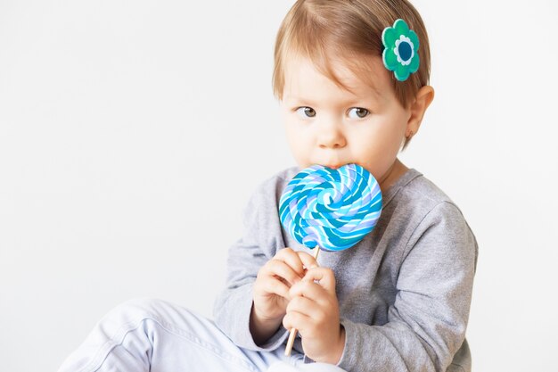 Foto menina comendo um pirulito