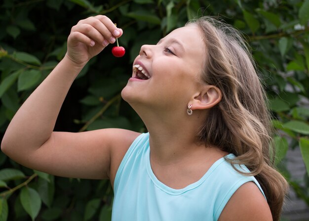 menina comendo uma cereja