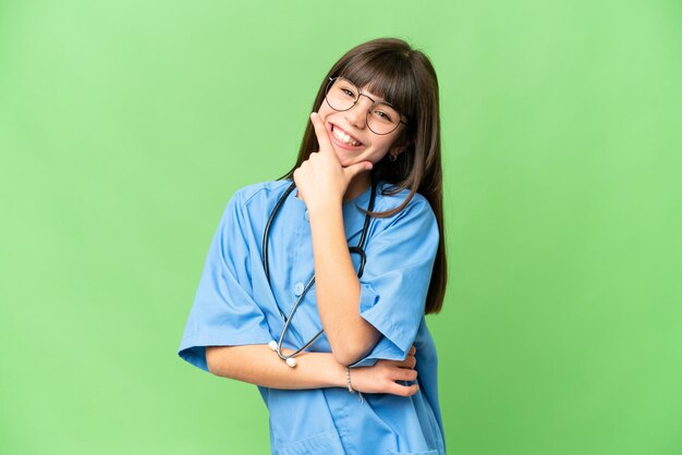 Menina como médica cirurgiã sobre fundo croma isolado sorrindo