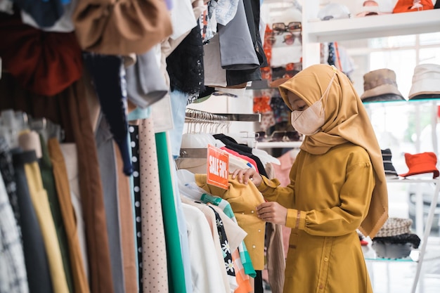 Menina comprando roupas novas em uma loja no shopping