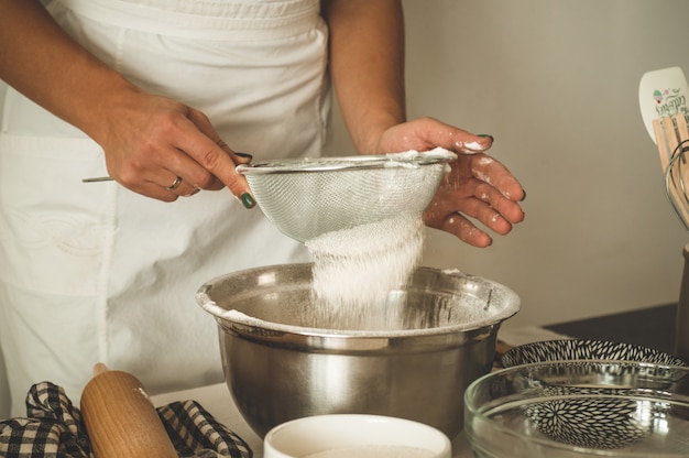 Menina confeiteiro preparando um bolo