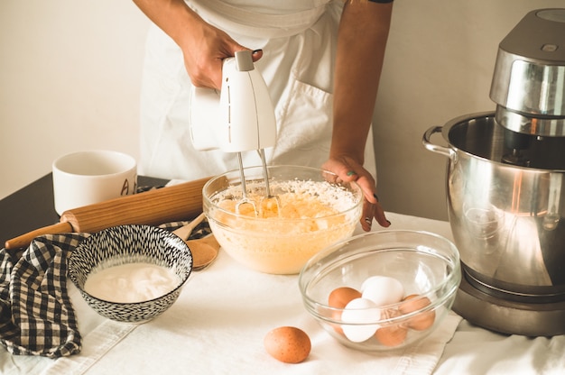 Menina confeiteiro preparando um bolo