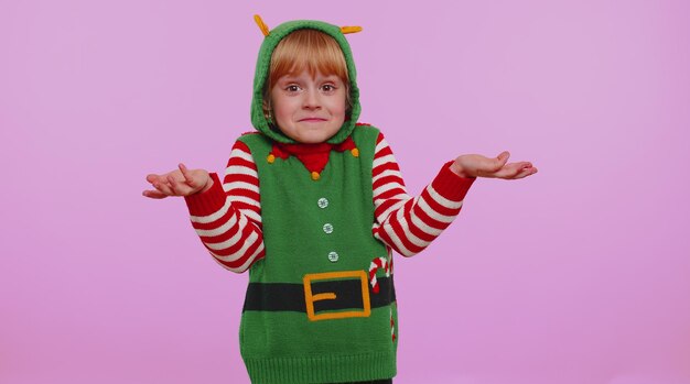 Foto menina confusa em traje de natal, envergonhada por uma pergunta ambígua, sem dúvidas, sem ideia.