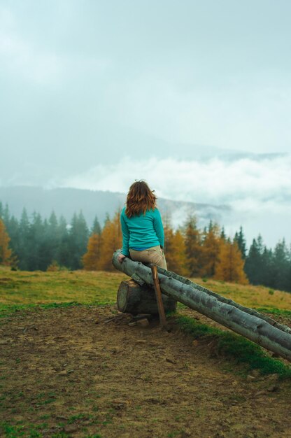 menina contra o pano de fundo da floresta de outono e montanhas paisagem nevoeiro viagem descanso recuperação em natu