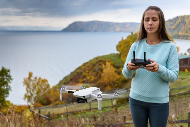 Foto menina controla um drone ao ar livre