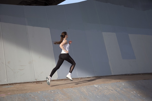 Menina corre debaixo da ponte