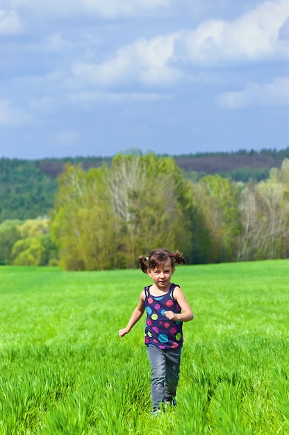 Menina correndo ao ar livre em campo verde