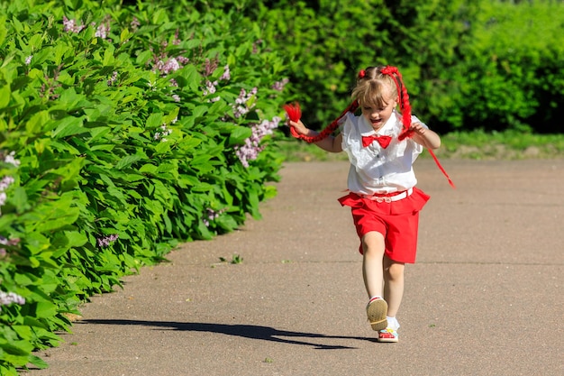 Menina correndo ao redor do parque no verão. Foto de alta qualidade