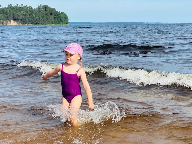 Menina correndo com salpicos no mar