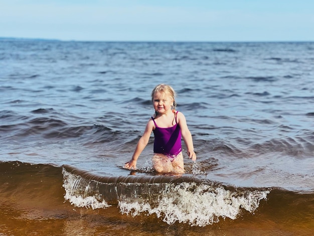 Menina correndo com salpicos no mar