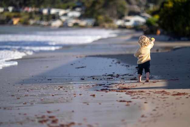 menina correndo na praia à beira-mar no verão