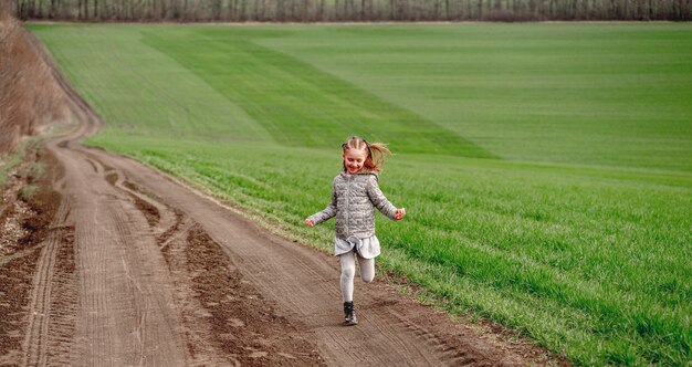 Menina correndo no campo de primavera