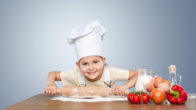 Menina cozinhando com farinha no fundo