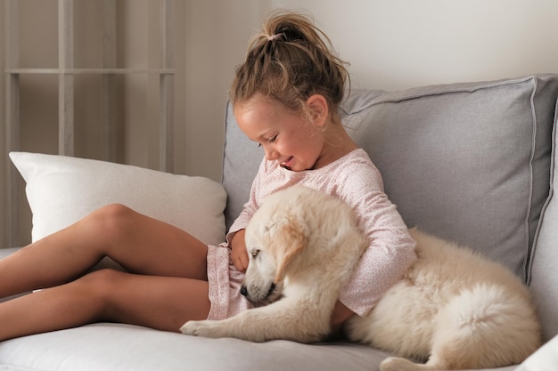 Menina criança abraça cachorrinho em casa