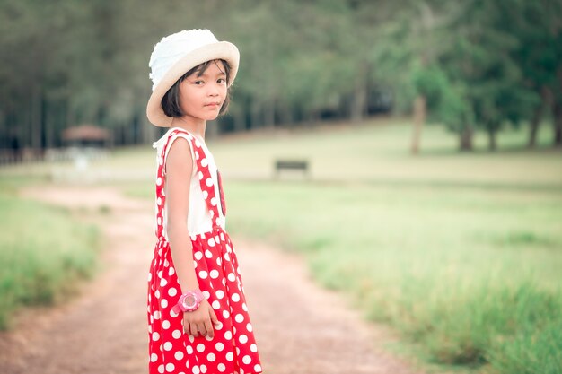 Menina criança andando e brincando no campo durante o dia