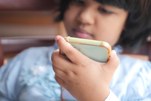 Menina criança assistindo desenho animado no telefone inteligente