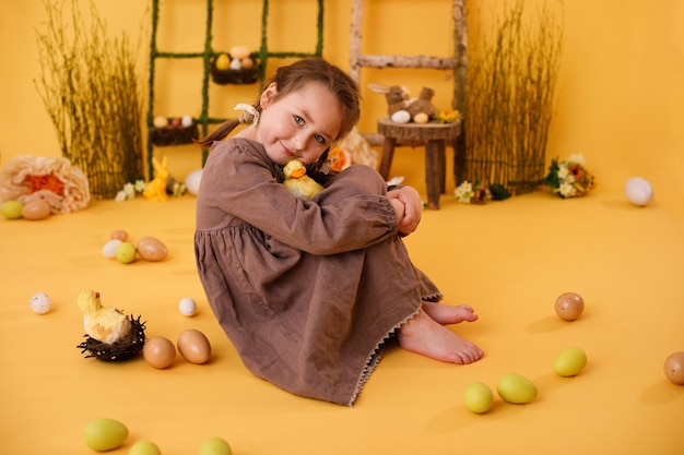 Menina criança brincando com ovos de páscoa e decoração tradicional de páscoa de pintinho em estilo rural