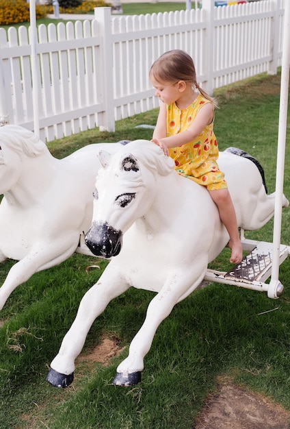 Menina criança brincando no parque infantil