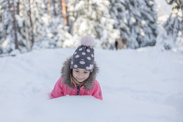 Menina criança caminhando no parque nevado