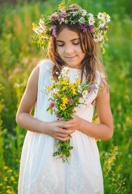 Menina criança com flores silvestres no verão Foco seletivo