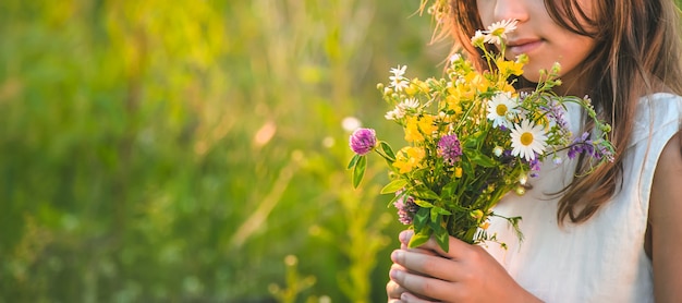 Menina criança com flores silvestres no verão